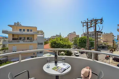 a balcony with a table and two glasses of wine at Elia Residences in Chania Town