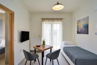 a bedroom with a bed and two chairs and a table at Elia Residences in Chania Town