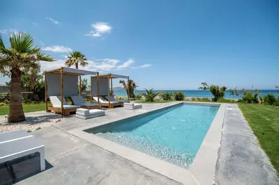 a villa with a swimming pool next to the ocean at Isalos Seafront Villa I Sea fragrance in Chania Town