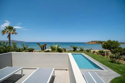 a villa with a swimming pool and the ocean at Isalos Seafront Villa I Sea fragrance in Chania Town