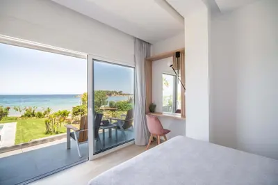 a bedroom with a bed and a view of the ocean at Isalos Seafront Villa I Sea fragrance in Chania Town