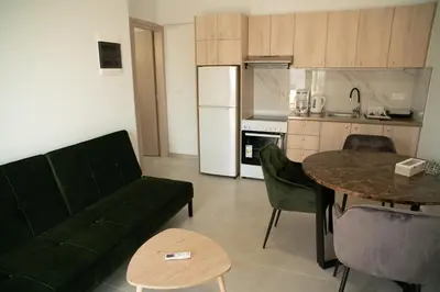 a living room with a couch and a table and a kitchen at Hello Village Chania in SFakianalíon