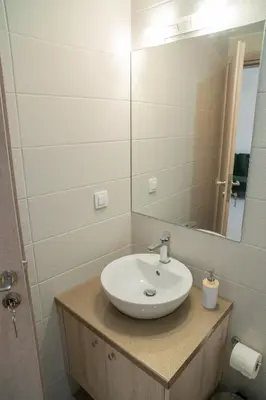 a bathroom with a sink and a mirror at Hello Village Chania in SFakianalíon