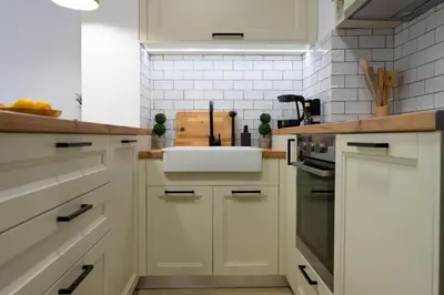a kitchen with white cabinets and a sink at Marilias Luxury Studio Apartment in Kissamos
