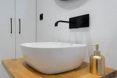 a white bowl on a wooden counter with a soap dispenser at Marilias Luxury Studio Apartment in Kissamos