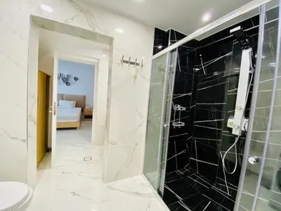 a bathroom with a shower and a toilet and a sink at Mare Monte Luxury Apartment in Kissamos