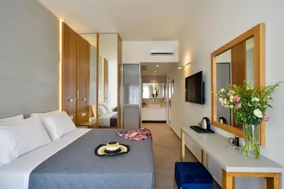 a hotel room with a bed and a mirror at Elia Platanias in Plataniás