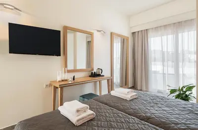 a hotel room with a bed and a television at Elia Platanias in Plataniás