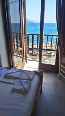 a room with a bed and a view of the ocean at Spamandos Rooms in Palaiochóra