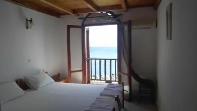 a room with two beds and a large window at Spamandos Rooms in Palaiochóra
