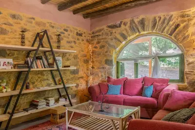 a living room with pink couches and a window at Hani Kastania - Chania retreat for families and groups for holidays and workshops in Sémbronas