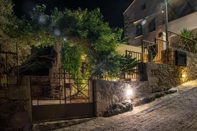 a gate to a house at night at STAMATOGIANNIS Traditional Apartments in Kalivianí