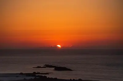 a sunset over the ocean with the sun in the horizon at Villa Maritini in Chania Town