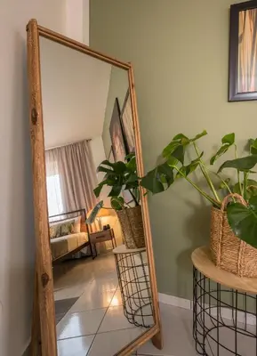 a mirror on a wooden stand in a living room at Ethyr City Living in Chania Town