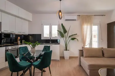a kitchen and living room with a glass table and chairs at Ethyr City Living in Chania Town