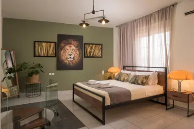 a bedroom with a bed with a lion painting on the wall at Ethyr City Living in Chania Town