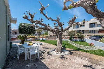 a patio with a table and chairs and a tree at Lahardi - Seaside House in Kissamos
