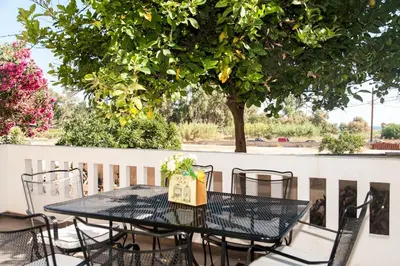 a black table and chairs on a balcony with a tree at ΠΑΡΑΘΑΛΑΣΣΙΟ in Ayiá
