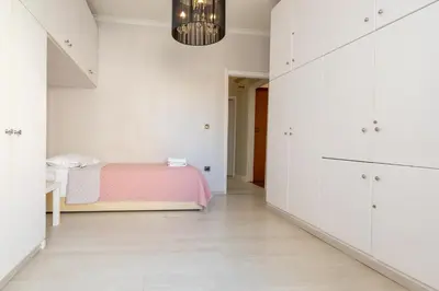 a bedroom with white walls and a pink bed at Chania dream apartment in Chania Town
