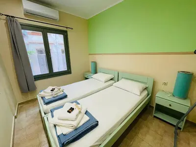 a small room with two beds and a window at Casa Mersini in Chania Town