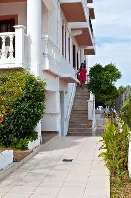 a woman walking down the stairs of a building at Captain Michalis Apartments - 750m from Kalamaki Beach in Galatás