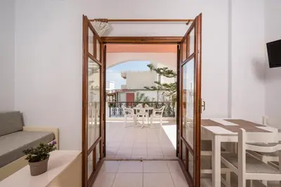 a room with a view of a balcony with a table at Captain Michalis Apartments - 750m from Kalamaki Beach in Galatás