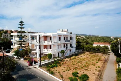 a white building on the side of a street at Captain Michalis Apartments - 750m from Kalamaki Beach in Galatás