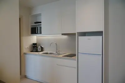 a white kitchen with a sink and a refrigerator at ANTEL Suites & Apartments in Chania Town