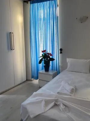 a bedroom with a white bed and a blue window at Casa Argo in Chania Town