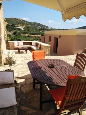 a wooden table and chairs on a patio at Villa Terpsi in Ravdhoúkha