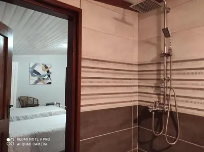a bathroom with a shower and a bedroom with a bed at Villa Terpsi in Ravdhoúkha