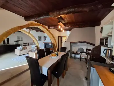 a kitchen and living room with a table and chairs at Villa Terpsi in Ravdhoúkha
