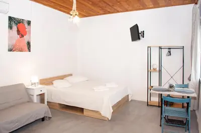 a bedroom with a bed and a couch and a table at Casa Elafonisi N2-10min from the beach in Plokamianá