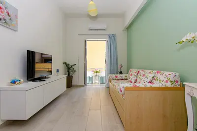 a living room with a couch and a tv at Belle Verte City Chania in Chania Town