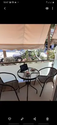 a table and two chairs on a balcony with a laptop at Chania Center Apartment in Chania Town