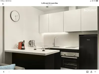 a kitchen with white cabinets and a black refrigerator at Chania Center Apartment in Chania Town