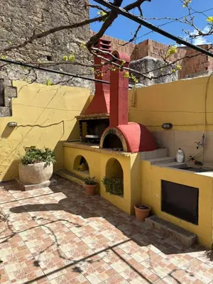 a building with a pizza oven on a patio at Nikos Traditional House in Maláthiros