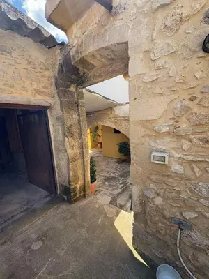 an entrance to a stone building with a stone wall at Nikos Traditional House in Maláthiros
