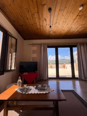 a living room with a table and a view of the desert at Nikos Traditional House in Maláthiros