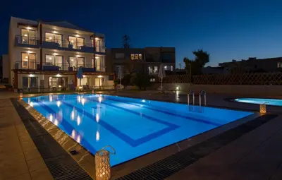 a swimming pool in front of a house at night at Giannarakis Beach in Stalos