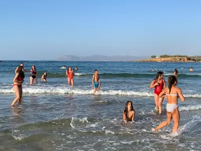 a group of people in the water at the beach at Ouranos Studios in Kalamaki Chanion
