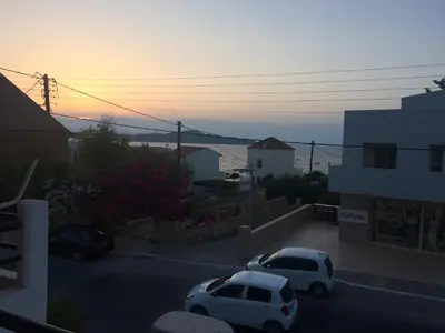 two cars parked in a parking lot at sunset at Ouranos Studios in Kalamaki Chanion