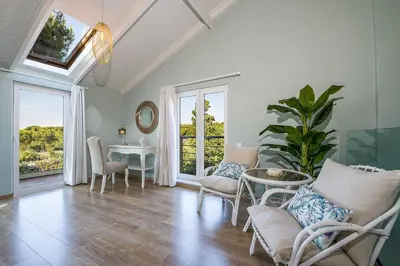 a living room with chairs and a table and windows at Casa di Goya in Chania Town