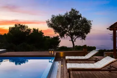 a swimming pool with two lounge chairs next to a house at Casa di Goya in Chania Town