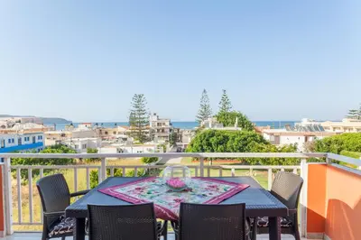 a table on a balcony with a view of the ocean at CHRISTINE SEASIDE APARTMENTS IN CHANIA in Stalos