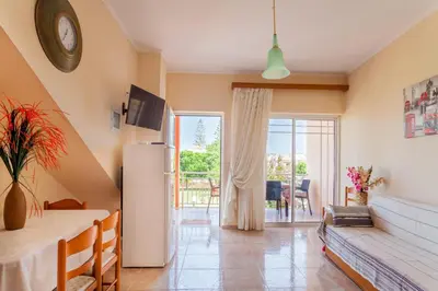 a living room with a couch and a table at CHRISTINE SEASIDE APARTMENTS IN CHANIA in Stalos