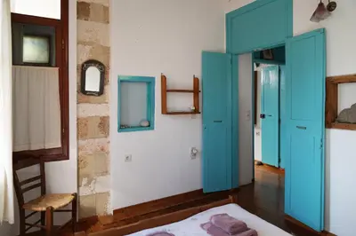 a room with a blue door and a chair at Lindas Convent Garden Home 4 in Chania Town