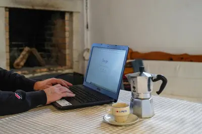 a person typing on a laptop computer on a table at Lindas Convent Garden Home 4 in Chania Town
