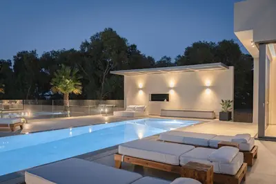 a swimming pool with chaise lounges and a house at Artemis Villa, Beachfront Retreat with Heated Pool, By ThinkVilla in Tavronitis
