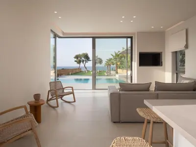 a living room with a couch and a table at Artemis Villa, Beachfront Retreat with Heated Pool, By ThinkVilla in Tavronitis